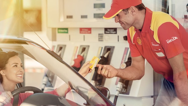 Жінка платить за паливо на заправній станції за допомогою Shell FuelCard