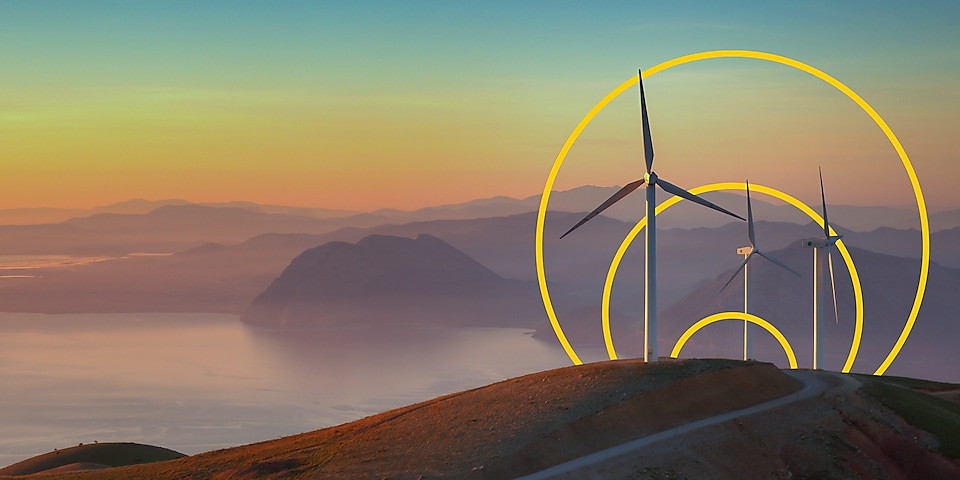 Фото трьох вітряних турбін на пагорбі з графічним зображенням «Досягнення нульових викиди»