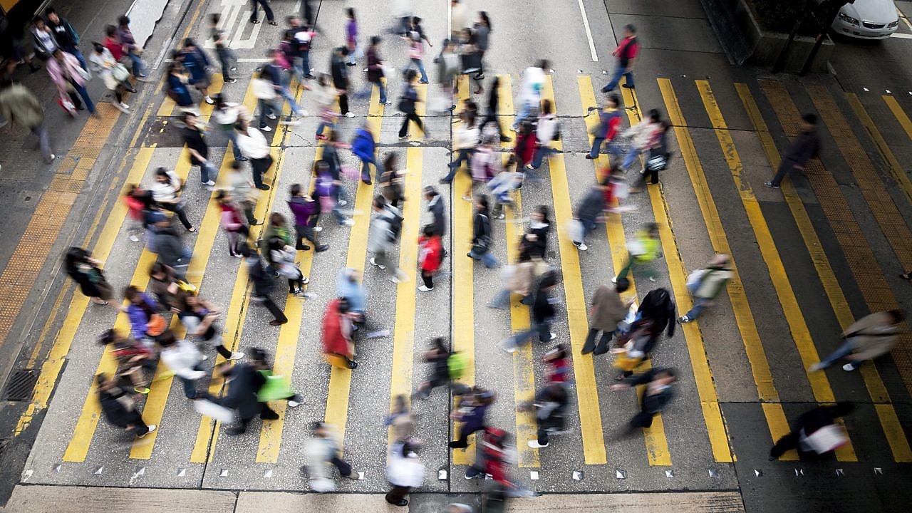 Люди перетинають жваву вулицю в Гонконгу