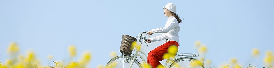 Молода жінка їде на велосипеді через поле влітку