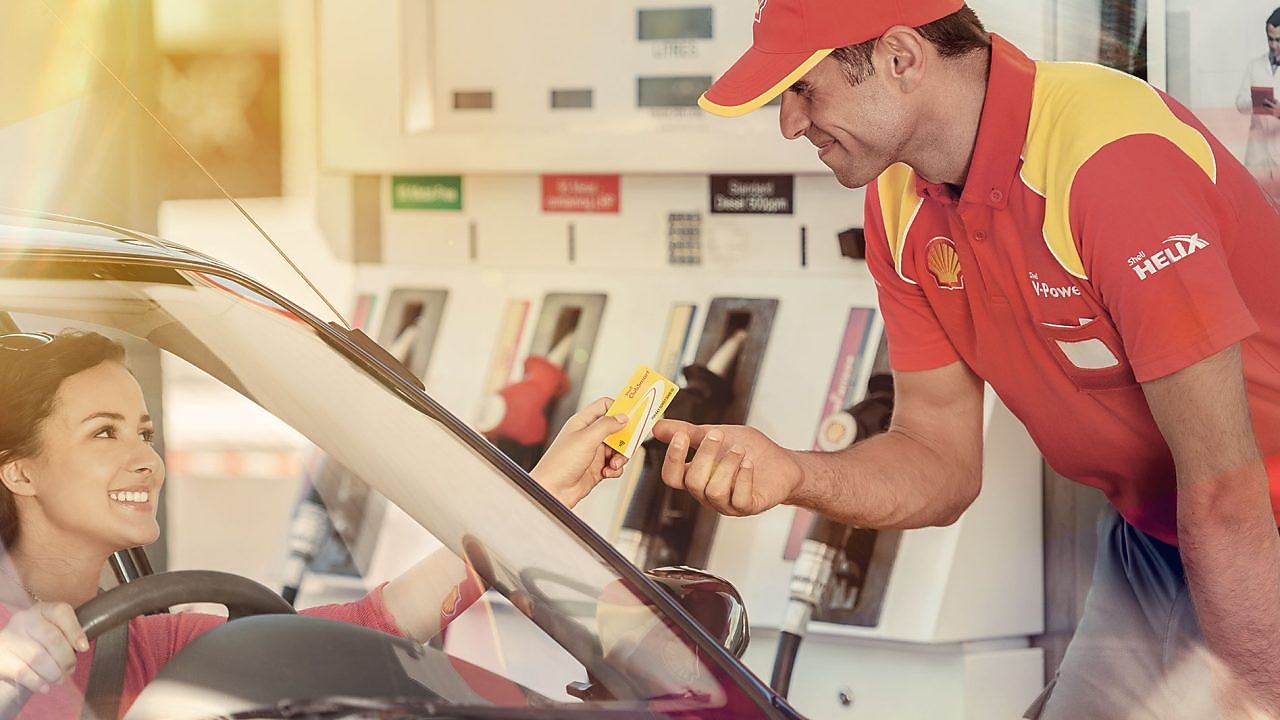 Жінка платить за паливо на заправній станції за допомогою Shell FuelCard