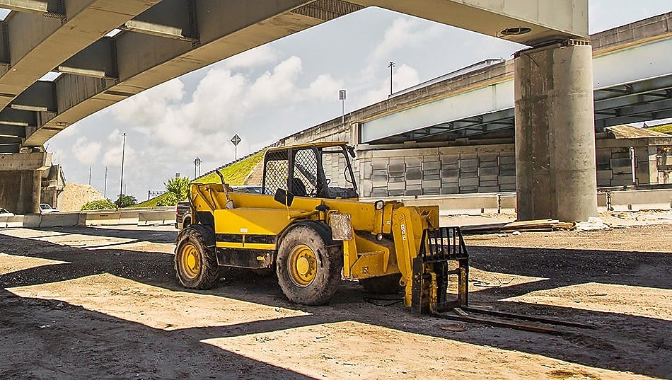 екскаватор під естакадою, яка будується