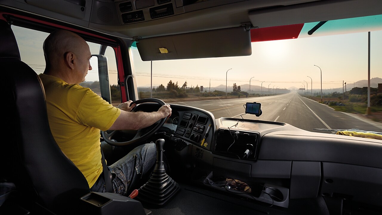 водій вантажного автомобіля прямує порожнім автошляхом