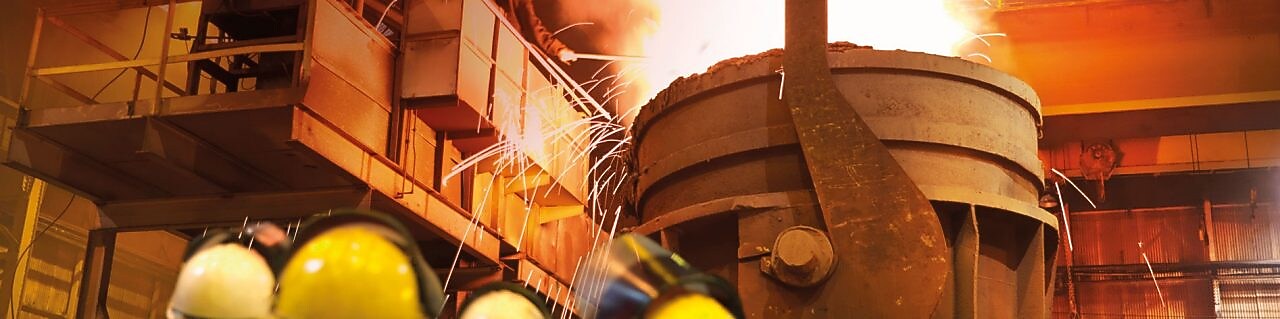 робітники слідкують за роботою важкого обладнання на металообробному заводі