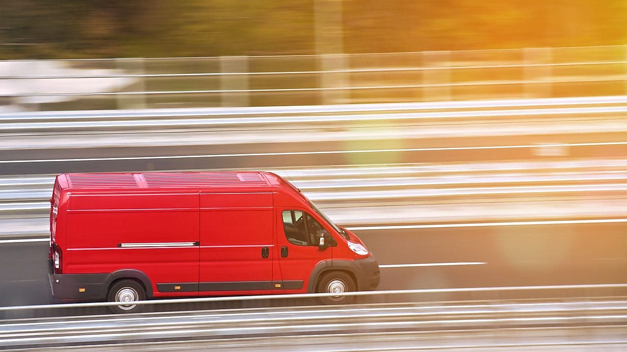 червона вантажівка на шосе