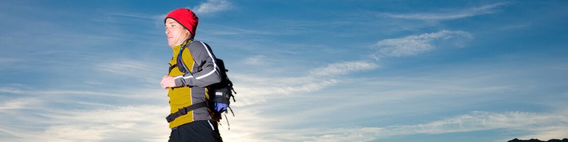 man with prosthetic leg, in running clothes, running in the hills in the early morning