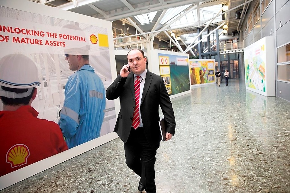 Andy Kneen walking and talking on the phone at a Shell office