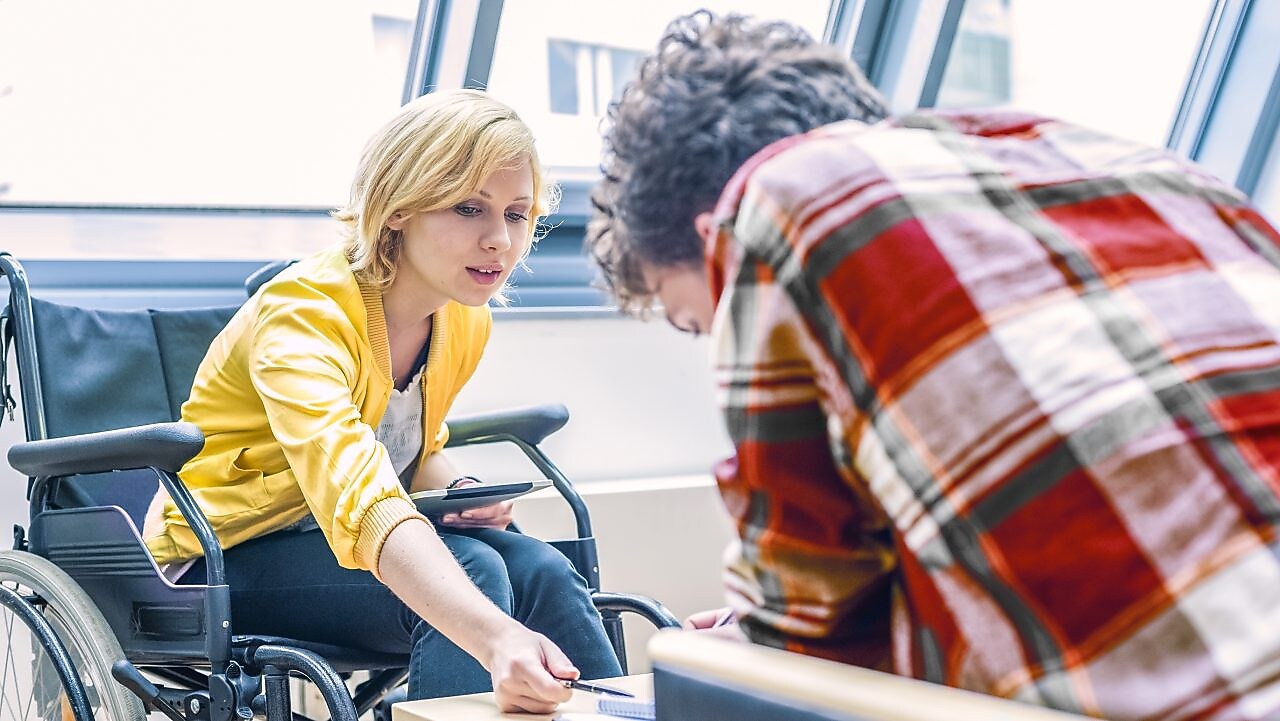 Woman in a wheelchair talking to a man