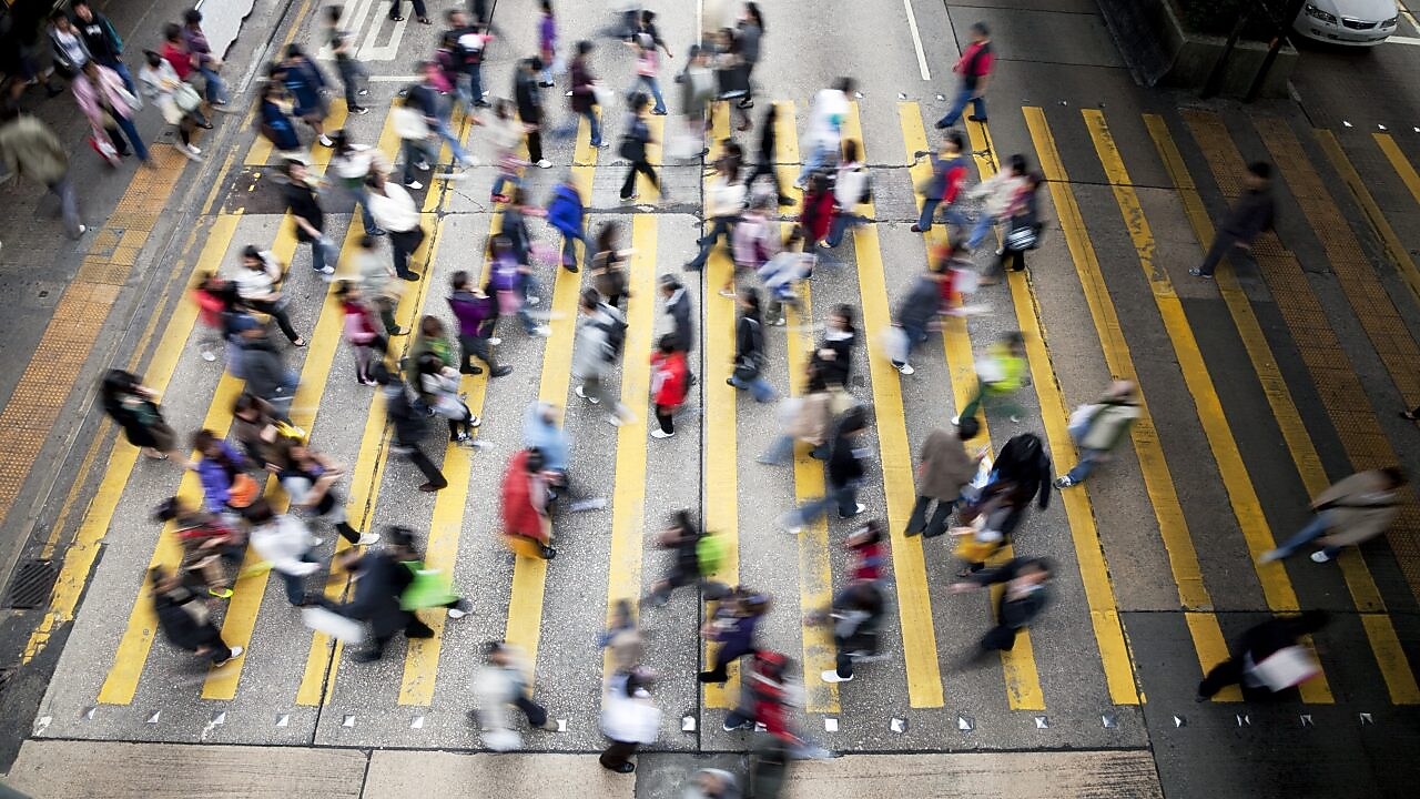 Люди перетинають жваву вулицю в Гонконгу