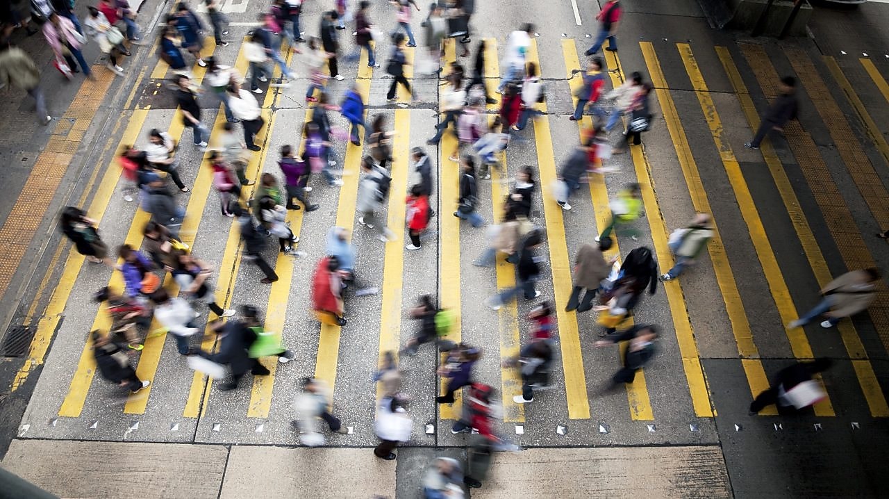 Люди перетинають жваву вулицю в Гонконгу