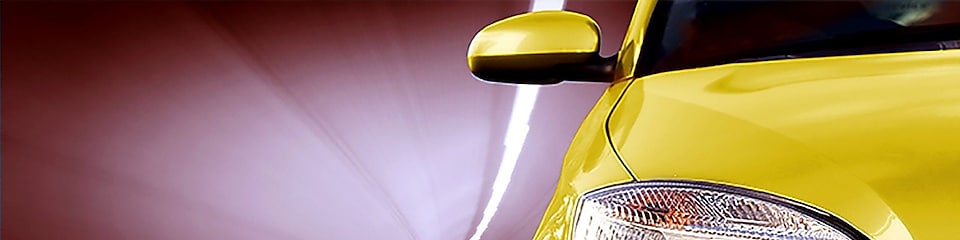 Жовтий автомобіль їде через тунель (вид спереду), бачимо праве переднє світло і бокове дзеркало