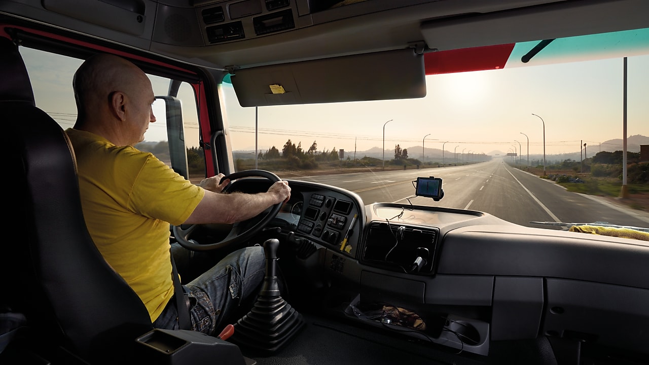 водій вантажного автомобіля прямує порожнім автошляхом