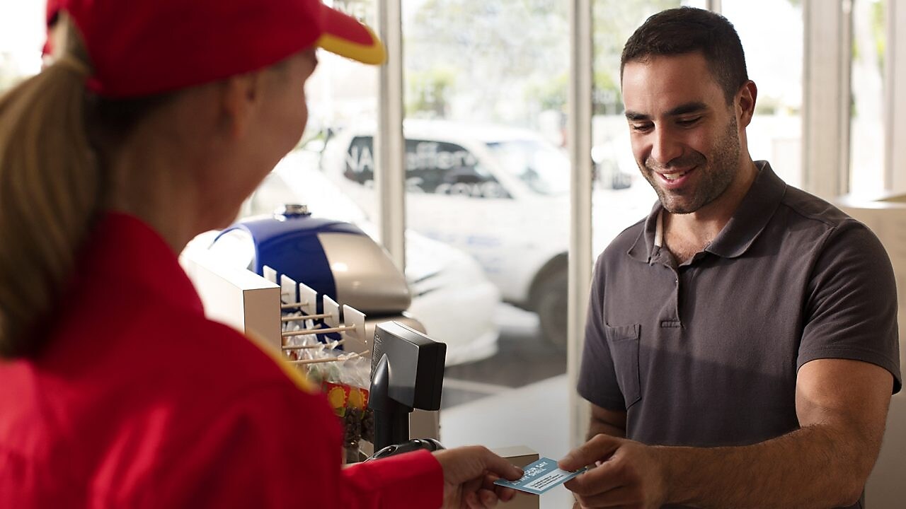 Man giving Loyalty Card to Shell Employee