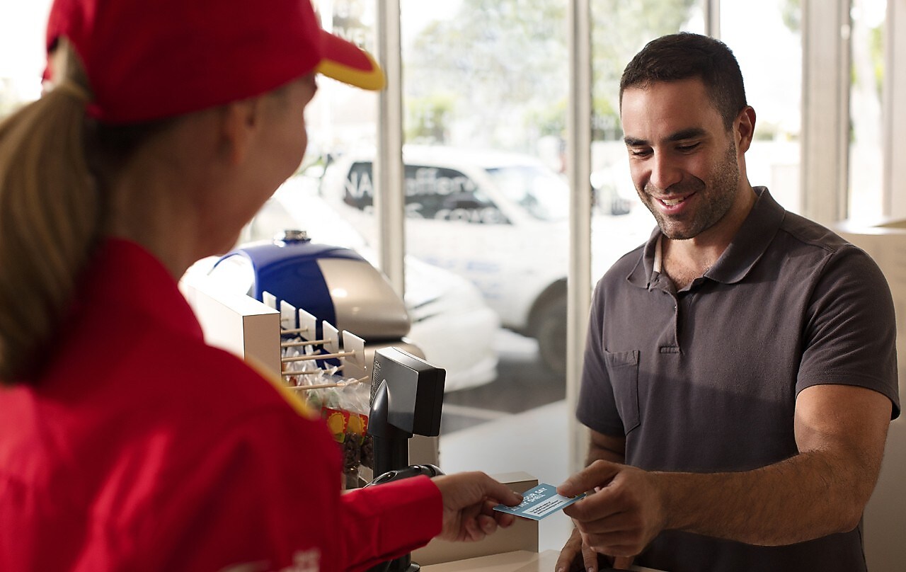 Man giving Loyalty Card to Shell Employee