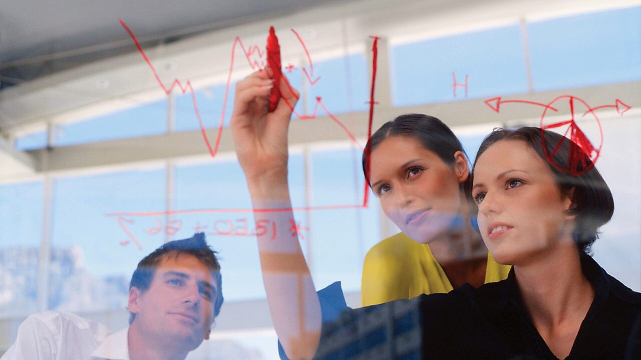 Жінка–підприємець малює графіки на склі