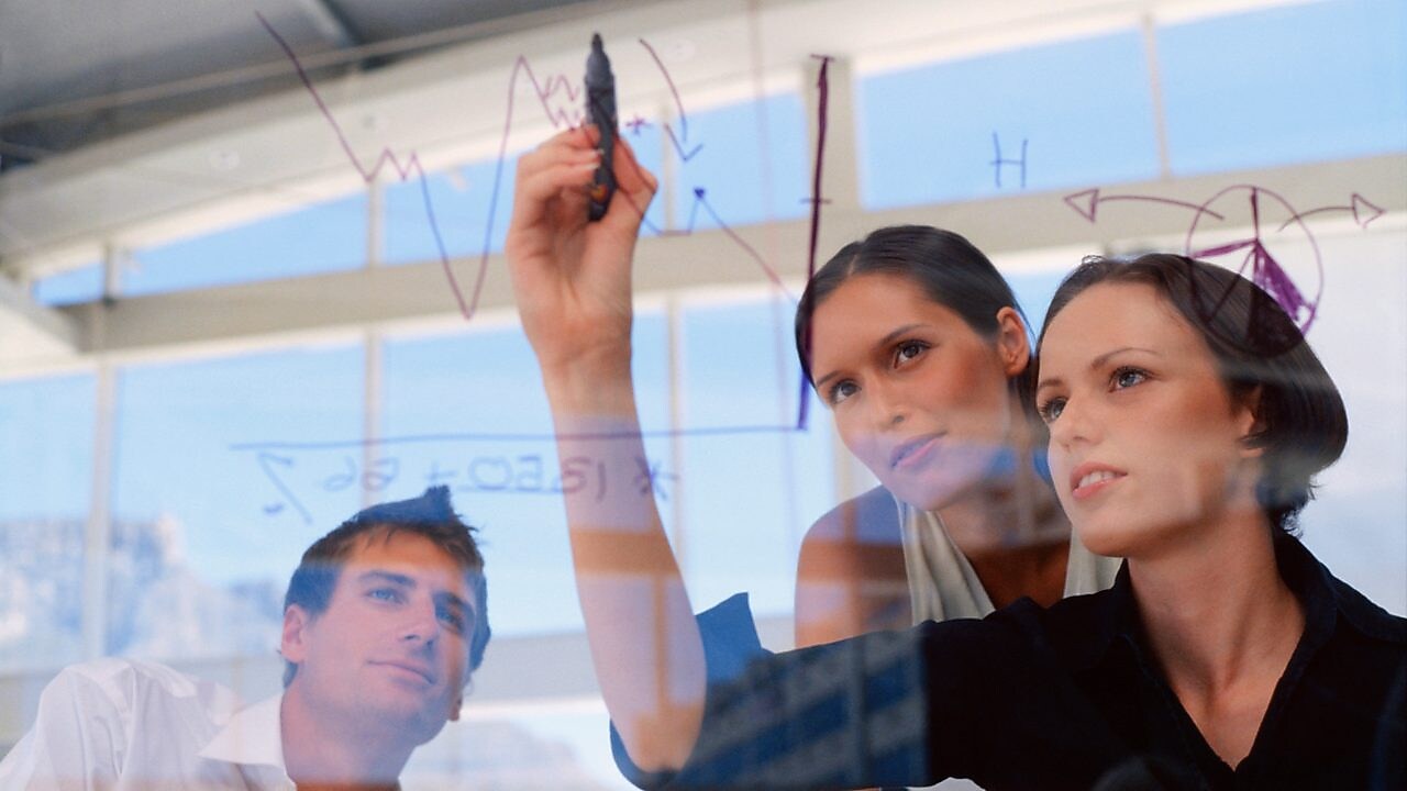 Жінка–підприємець малює графіки на склі