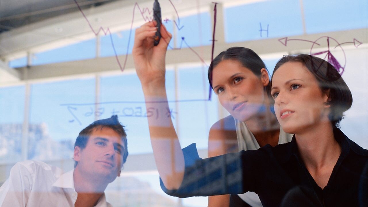 Жінка–підприємець малює графіки на склі